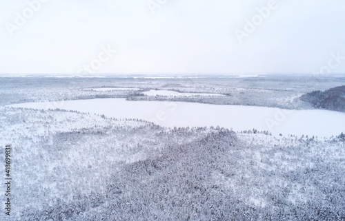 Snow covered forest protected forest reserve with lakes in Estonia by drone view © catcha