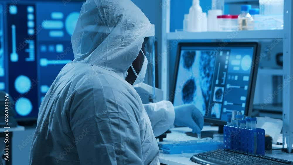 African-American doctor is doing a science experiments and developing vaccine in a modern laboratory. Genetic engineers workplace. The concept of science and medicine. African-American doctor is doing a science experiments and developing vaccine in a modern laboratory. Genetic engineers workplace. The concept of science and medicine.