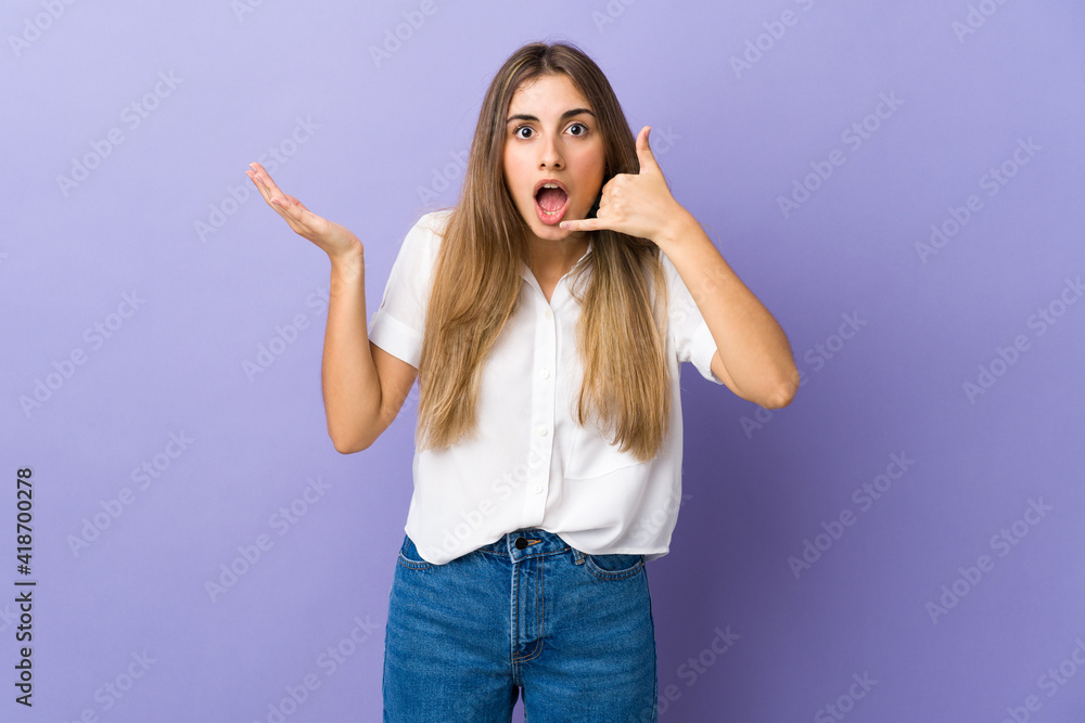 Young woman over isolated purple background making phone gesture and doubting