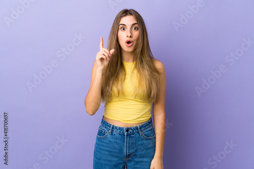 Young woman over isolated purple background intending to realizes the solution while lifting a finger up