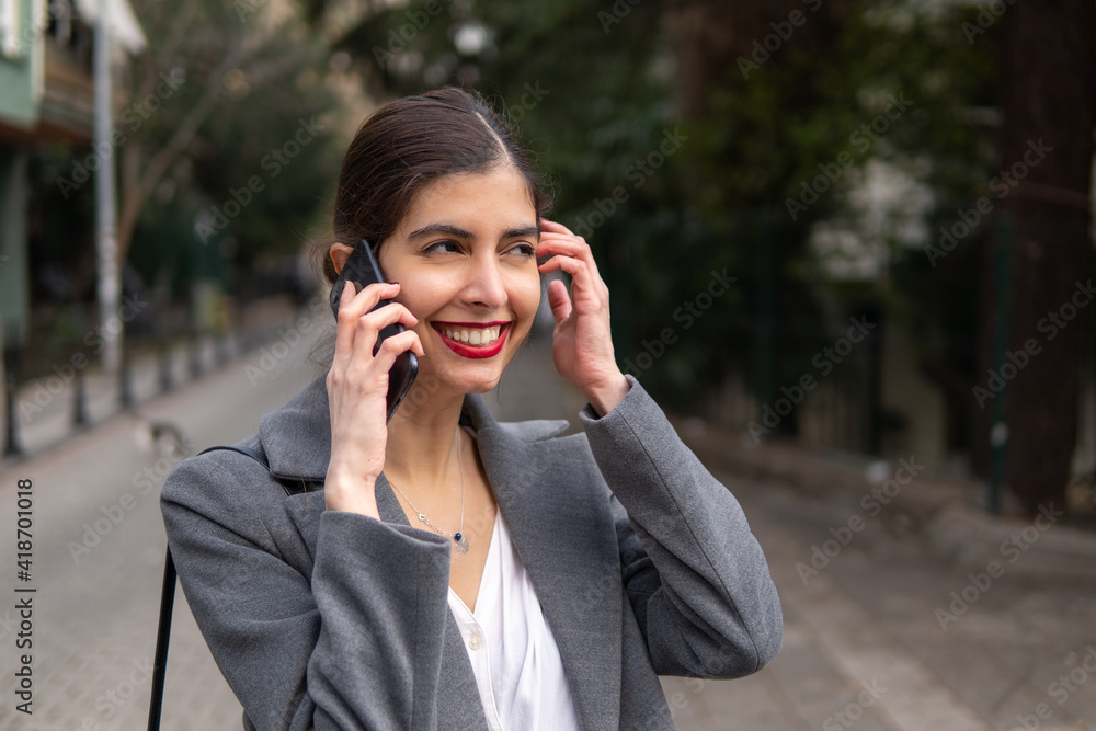 Businesswoman talking on the mobile phone with a beautiful smile and red lipstick Businesswoman talking on the mobile phone with a beautiful smile and red lipstick