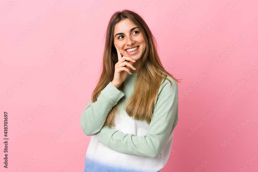 Young woman over isolated pink background thinking an idea while looking up Young woman over isolated pink background thinking an idea while looking up