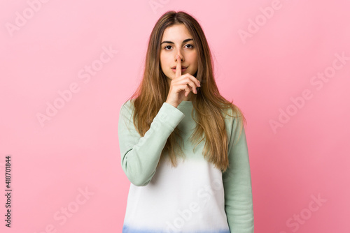 Young woman over isolated pink background showing a sign of silence gesture putting finger in mouth