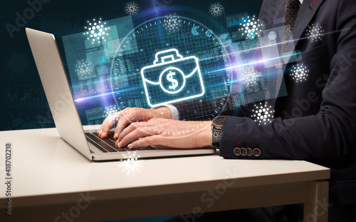 business hand working in stock market with briefcase icons coming out from laptop screen