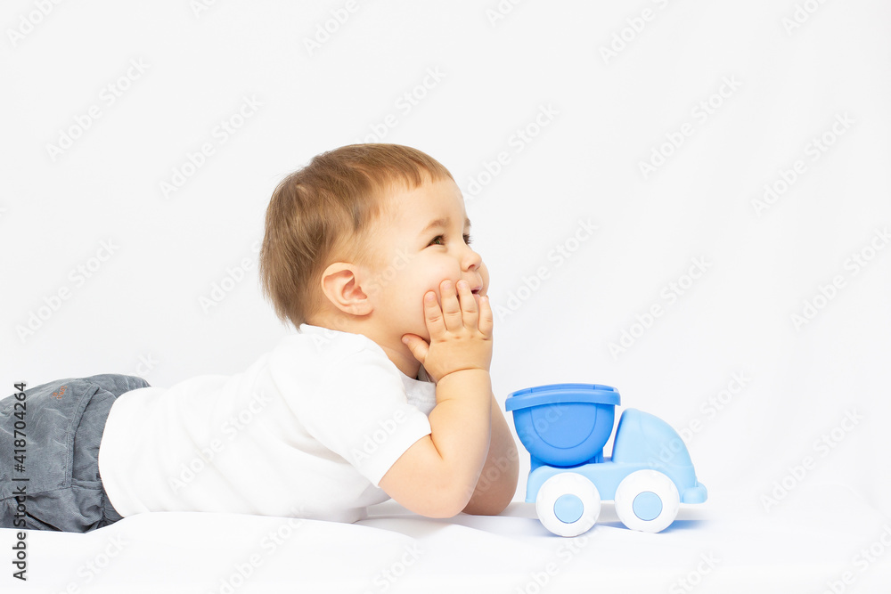 smiling kid playing with blue toy on white background smiling kid playing with blue toy on white background