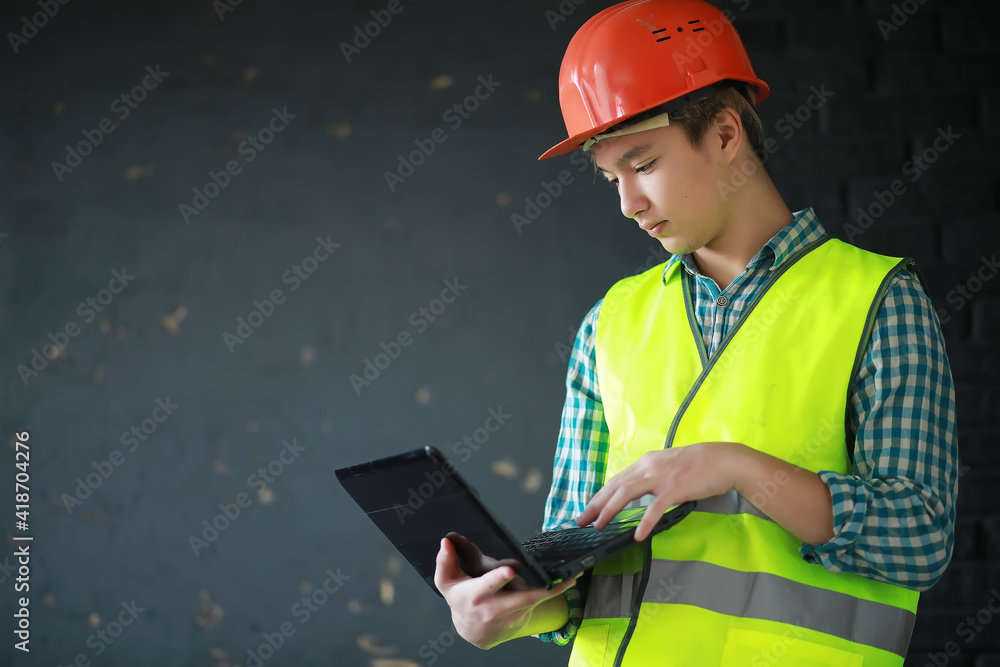 Asian man in protective helmet and construction waistcoat Asian man in protective helmet and construction waistcoat