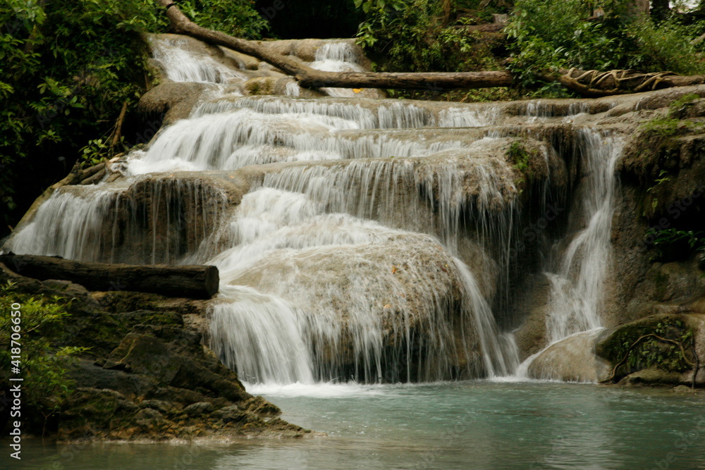 natural pool with a waterfall Kanchanuburi Thailand. Tree across a waterfall. Crystal blue water lagoon natural pool with a waterfall Kanchanuburi Thailand. Tree across a waterfall. Crystal blue water lagoon