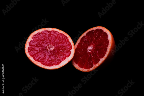 Two parts of fresh grapefruit on dark background  closeup. Healthy diet concept