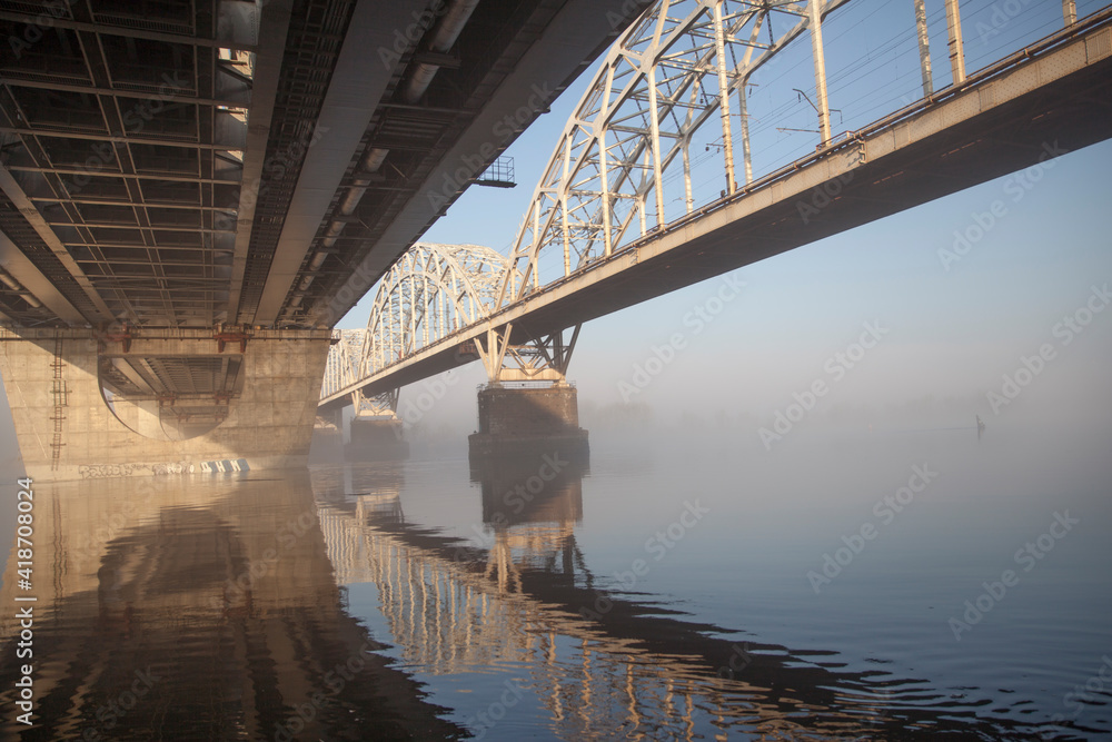 A bridge over a large river.. Fog on the river in early spring