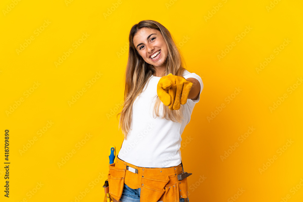 Young hispanic electrician woman over isolated yellow wall pointing front with happy expression Young hispanic electrician woman over isolated yellow wall pointing front with happy expression