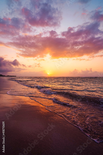 beautiful golden sunset on the beach over the sea with some dreamy clouds © Hanjin