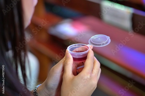 Woman holding wine in a Holy communion. selective focus