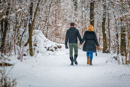 couple walking in winter forest