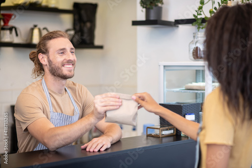 Man at counter giving package to woman