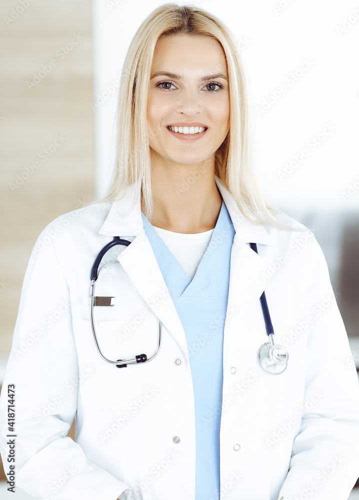 Woman-doctor at work in clinic happy of her profession. Blond female physician controls medication history record and medical exam results. Medicine concept Woman-doctor at work in clinic happy of her profession. Blond female physician controls medication history record and medical exam results. Medicine concept