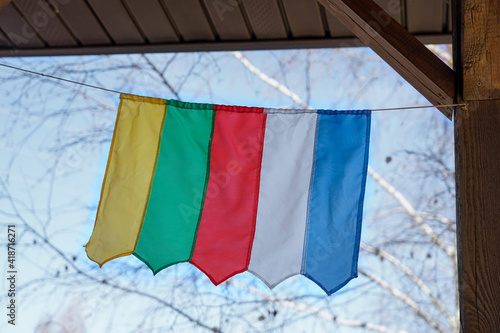 a Buddhist five-color flag, a symbol of energies, hangs in the wind near the temple