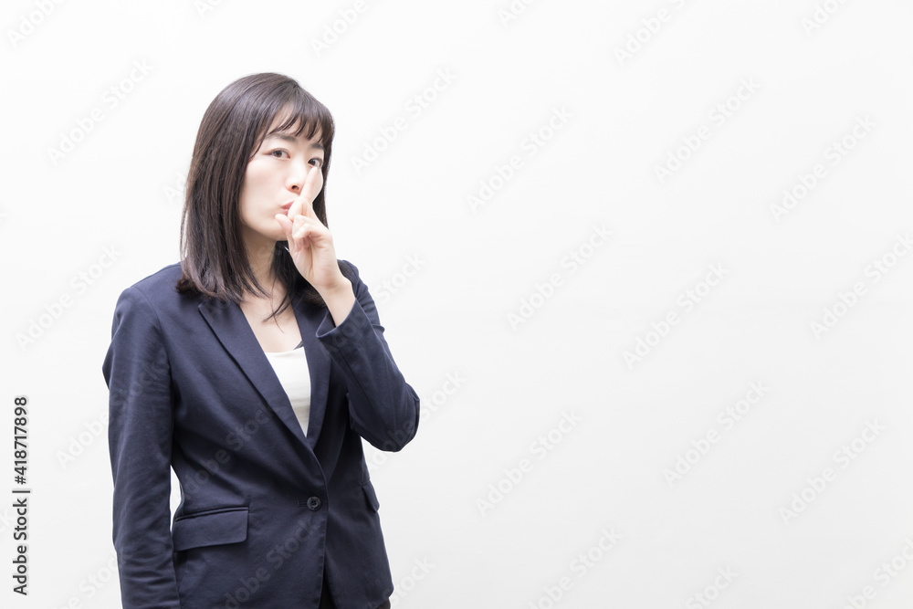 Woman raises her index finger in front of her mouth (gesture) Woman raises her index finger in front of her mouth (gesture)