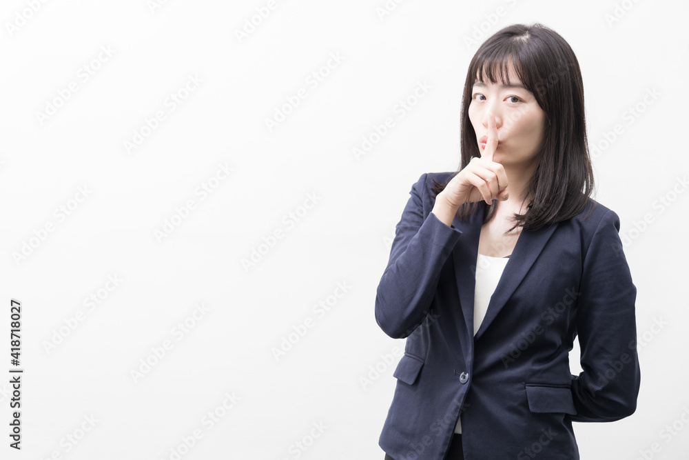 Woman raises her index finger in front of her mouth (gesture) Woman raises her index finger in front of her mouth (gesture)