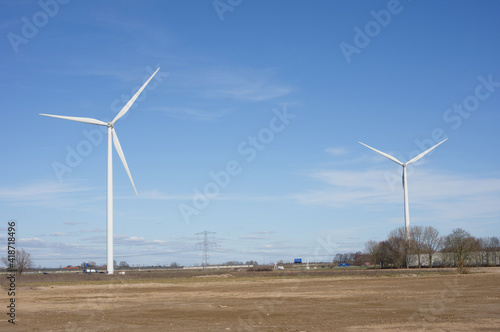 Two modern windmills for electric power production with a clear blue sky