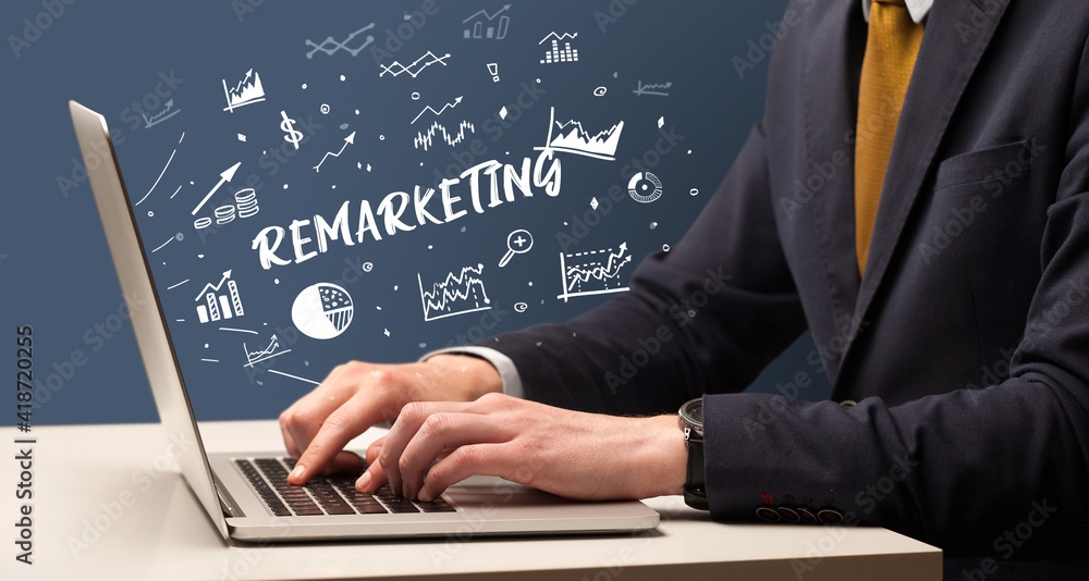 Businessman working on laptop with REMARKETING inscription, modern business concept Businessman working on laptop with REMARKETING inscription, modern business concept