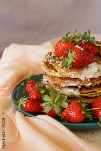 homemade pancakes with strawberries and honey on the table