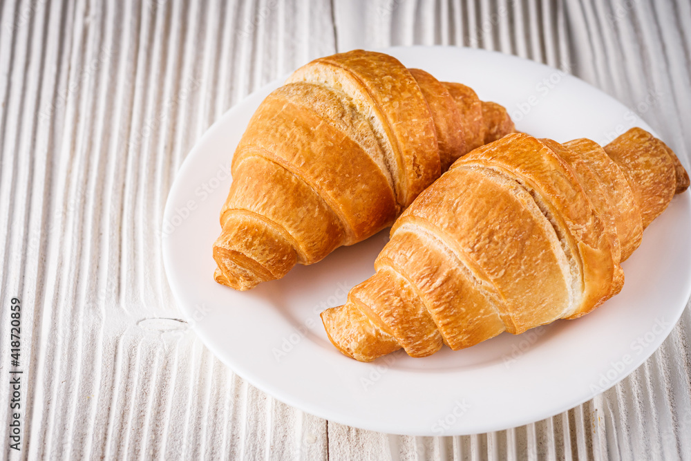 delicious fresh croissant on a white wooden rustic background