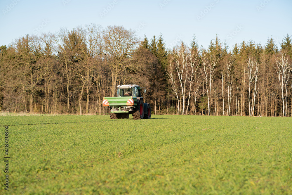 Düngerverordnung - Landwirt beim Dünger streuen auf einem Feld, landwirtschaftliches Symbolfoto.