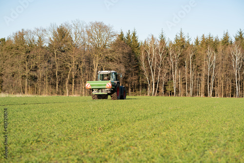 Düngerverordnung - Landwirt beim Dünger streuen auf einem Feld, landwirtschaftliches Symbolfoto.