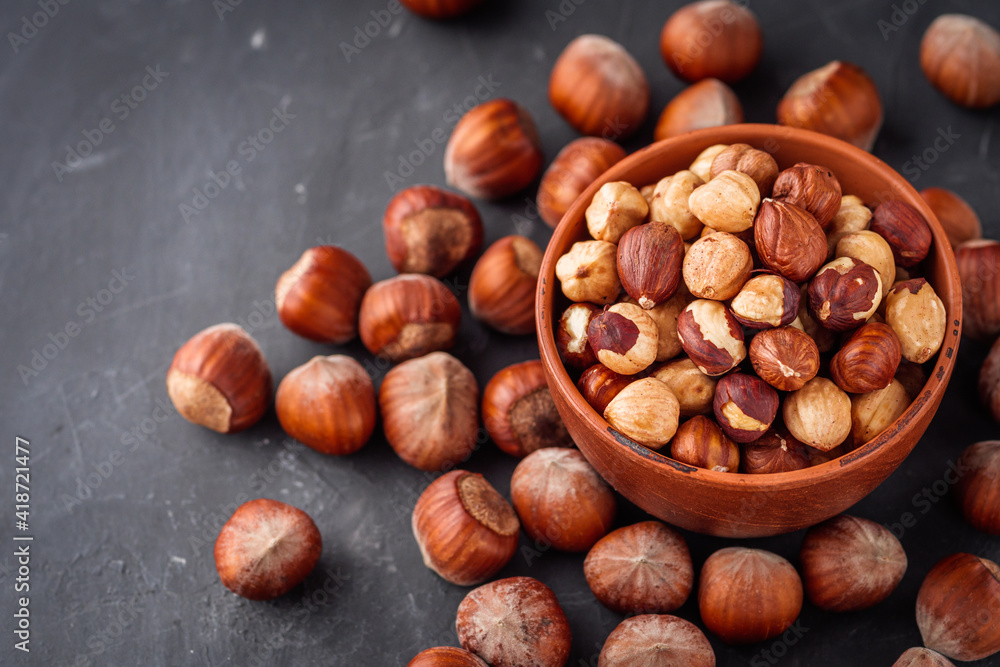 fresh natural hazelnuts on a dark stone background fresh natural hazelnuts on a dark stone background