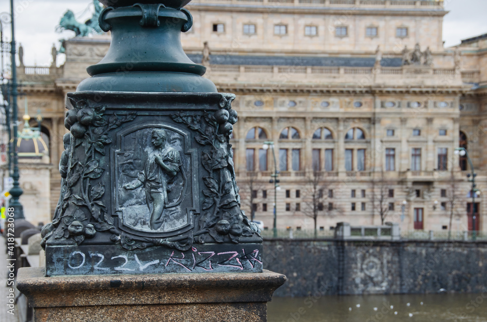 Fototapeta premium Detail of a historical lamp on Legion Bridge with National Theatre behind it, Prague, Czech Republic
