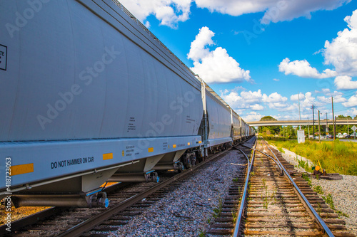 A long train and train track with blue sky and clouds background