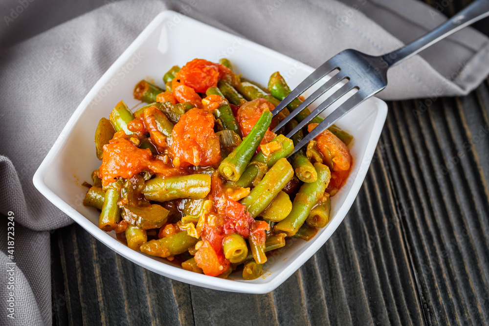 stewed green beans on a dark wooden rustic background stewed green beans on a dark wooden rustic background