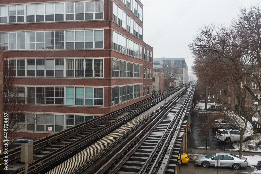 Vintage elevated metro tracks cutting through business district on overcast day in urban Chicago