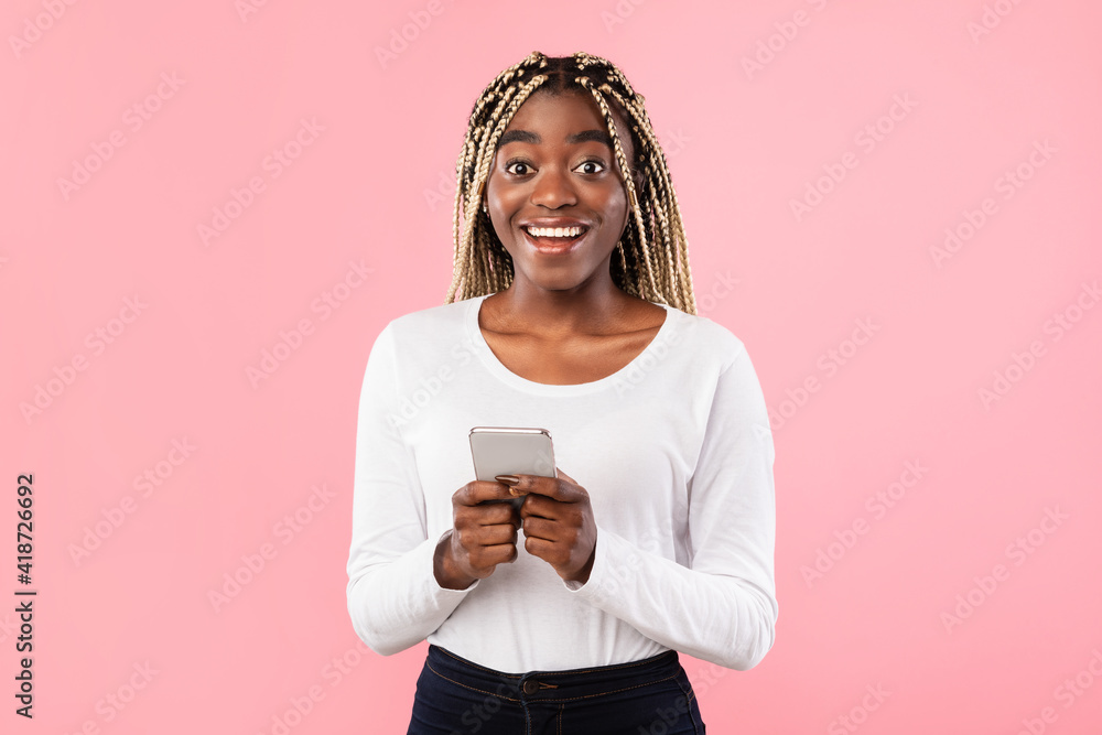 Excited black lady using mobile phone at studio Excited black lady using mobile phone at studio