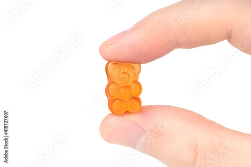 Orange gummy bear candy isolated on white photo