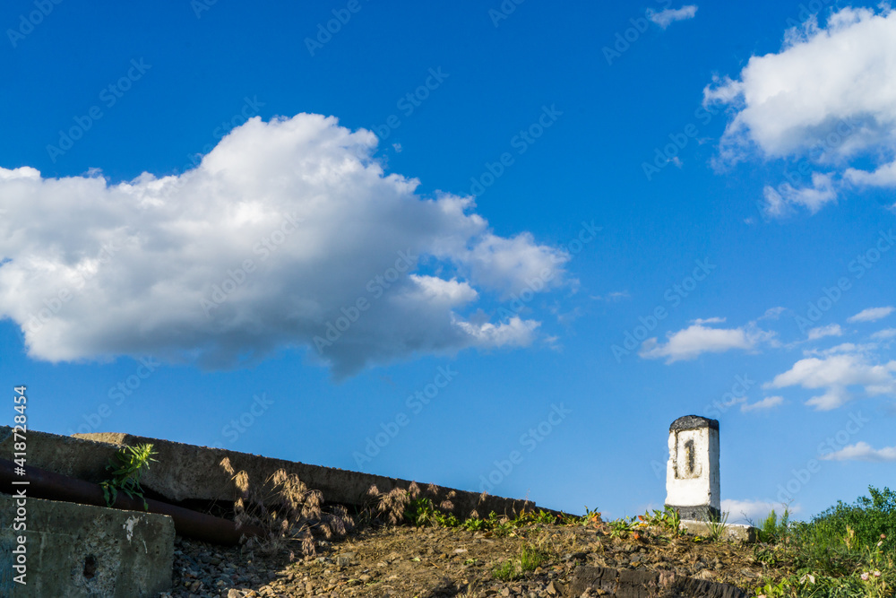 Railway post on the background of a blue sky with clouds.