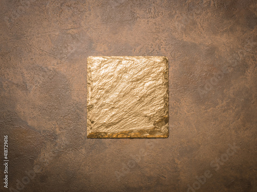 gold tile on brown background