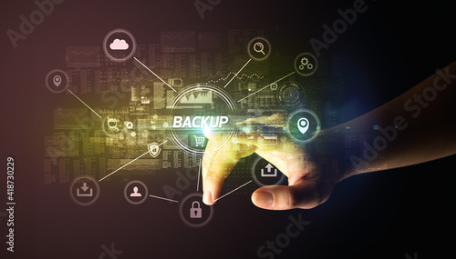Hand touching BACKUP inscription, Cybersecurity concept