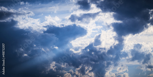Rays of sunlight breaking through dark clouds.