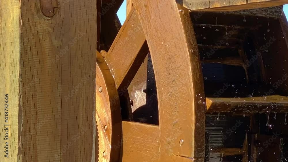 Wooden wheel of watermill turns around, water splashing on paddles close up Wooden wheel of watermill turns around, water splashing on paddles close up