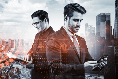 Two handsome businessman in suits try to find new tech approaches to solve problems at research and development department. Fintech hologram icons over Singapore background. © VideoFlow