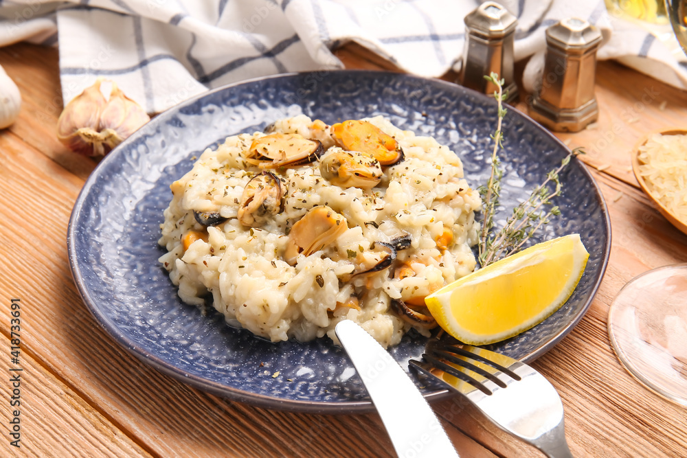 Plate with tasty risotto on wooden background