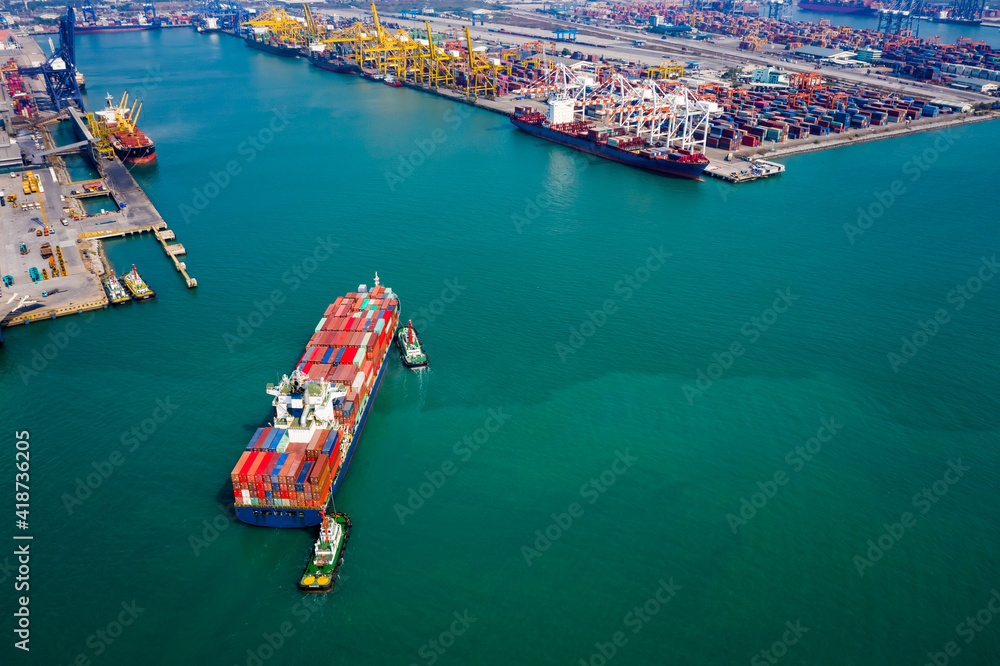 Aerial top view Tugboat pushing container ship  in sea port Thailand
