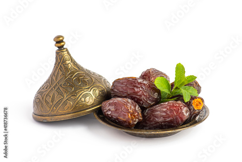 HURMA, Dates. Dried dates fruit with bronze bowls on white background. Popular fruit of Ramadan. . photo