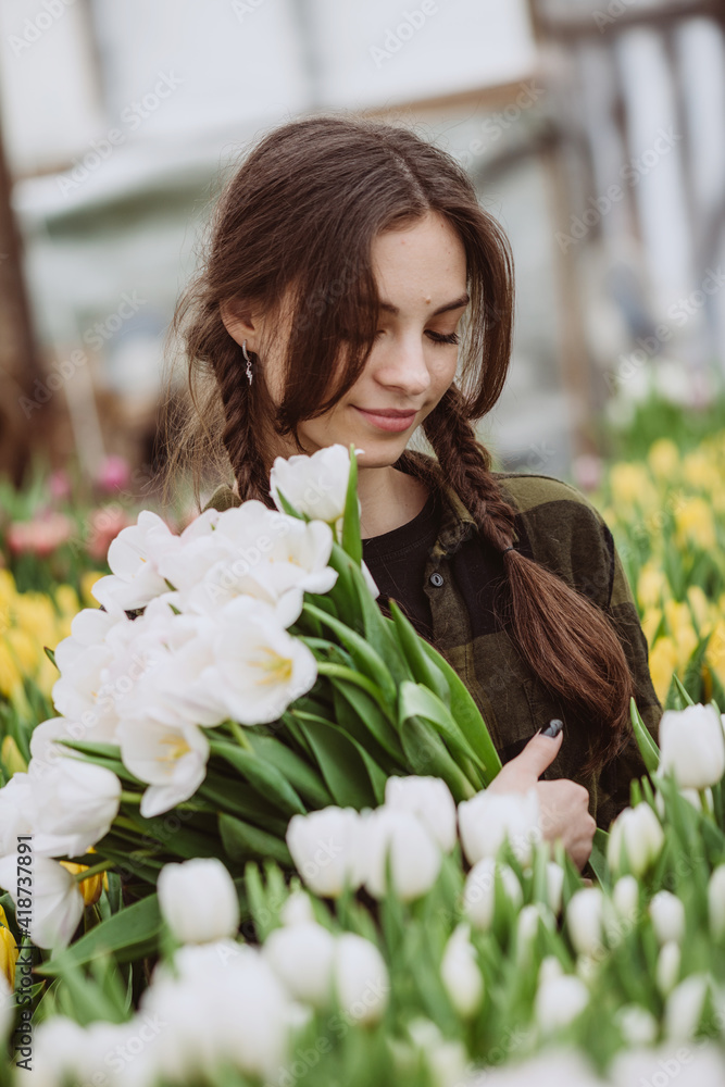 Young woman with a bouquet of spring flowers tulips. Soft selective focus, defocus.