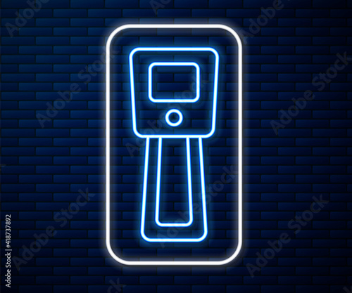 Glowing neon line Digital contactless thermometer with infrared light icon isolated on brick wall background. Vector.