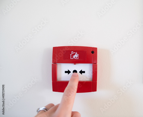 Finger ready to press a fire alarm button