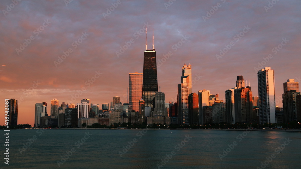 Chicago skyline across Lake Michigan at sunset viewed from North Avenue Beach. Long exposure.