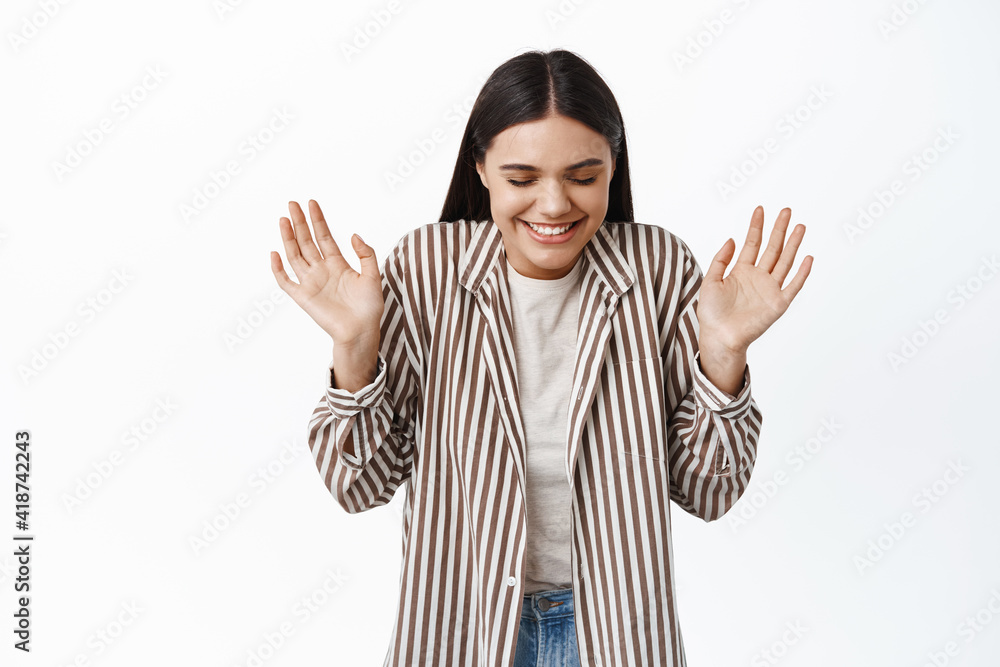 Portrait of cheerful dreamy woman close eyes and laugh, raising hands up happy, smiling with delight, standing against white background Portrait of cheerful dreamy woman close eyes and laugh, raising hands up happy, smiling with delight, standing against white background