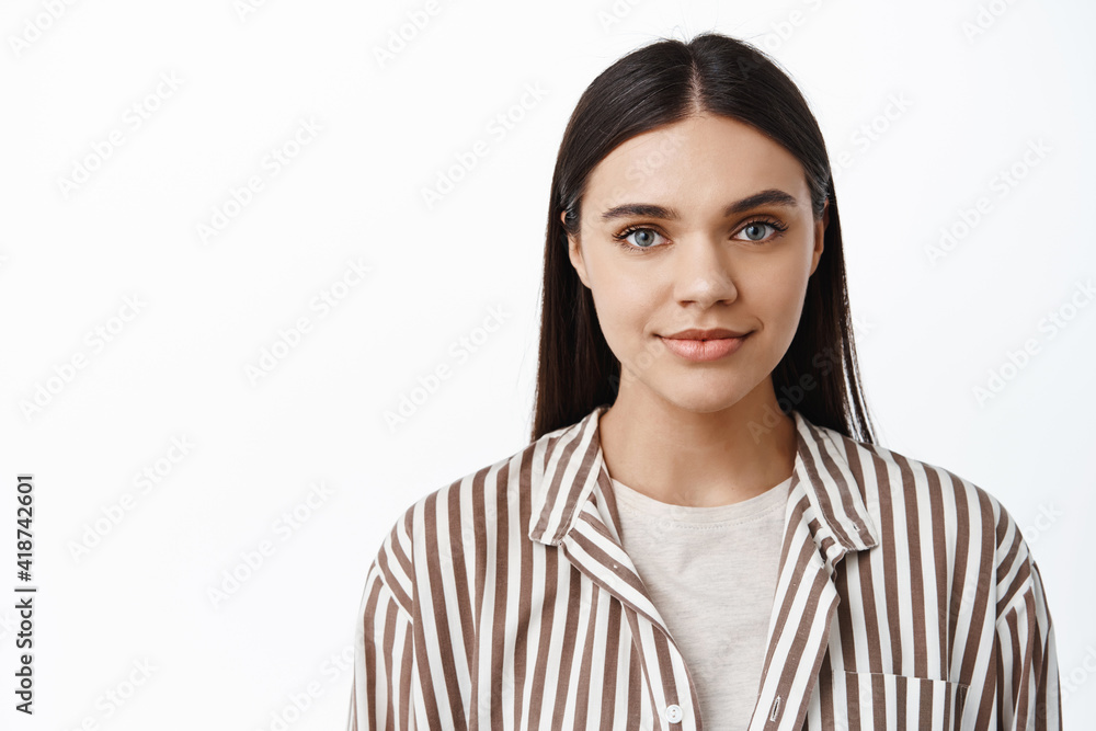 Close up portrait of stylish modern woman in trendy jacket, with natural light make up on, smiling tenderly and looking at camera, standing over white background Close up portrait of stylish modern woman in trendy jacket, with natural light make up on, smiling tenderly and looking at camera, standing over white background